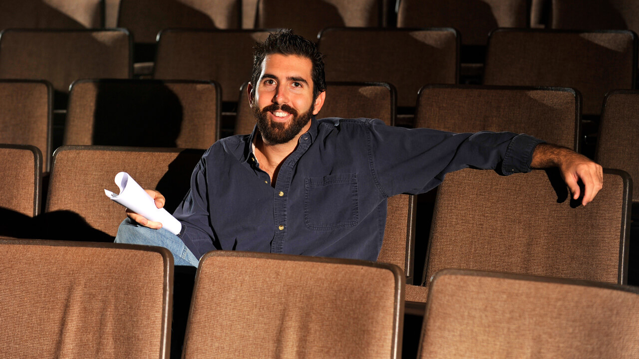 Kevin Daly sits in the seating area of the Theatre Arts Center