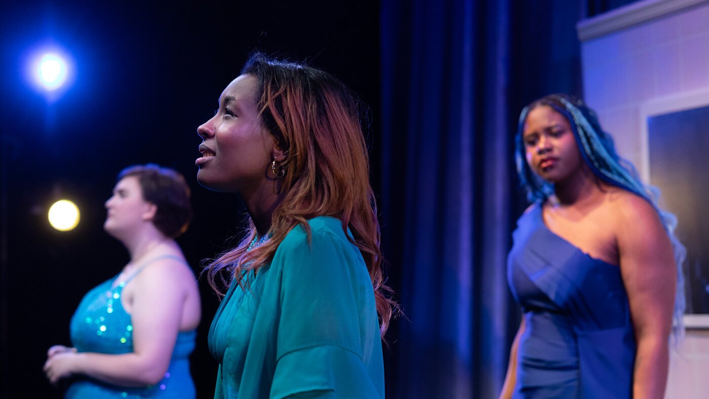 Three Quinnipiac Theater students in character during a production.