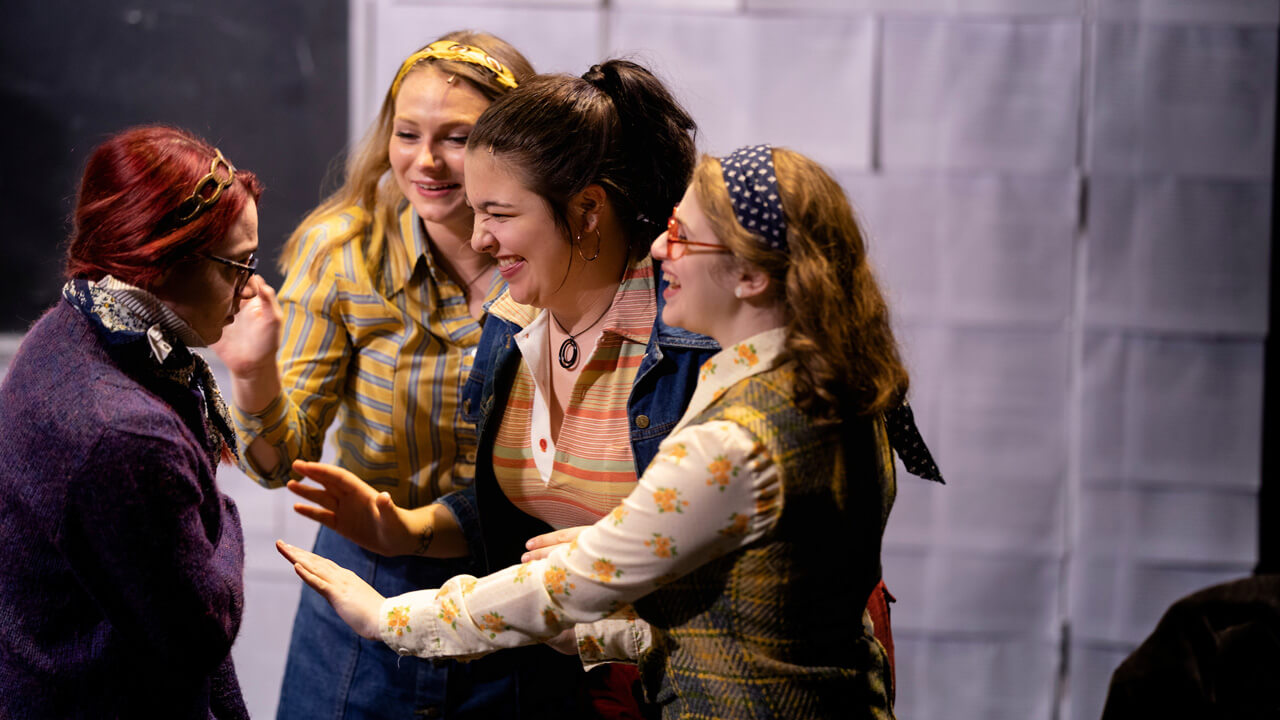 A group of 4 female student actors on stage for the production, Rage
